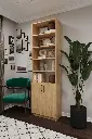 Safir meşe kitaplık, açık raflarda objeler, kapaklı alt dolapta kitaplar; yeşil koltuklu çalışma odasında.