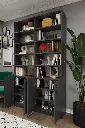 K-46 koyu gri kitaplığın açık kapaklı alt dolapları; iç raflarda kitaplar ve dekoratif objeler yer alıyor.