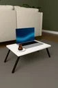 Katlanır laptop sehpası LAPTOPMASA01 Beyaz salonda halı üstünde yer sehpası olarak, laptop ve çay bardağıyla.