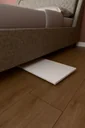 Katlanır laptop sehpası LAPTOPMASA01 Beyaz ayakları katlanmış hâlde yatağın altına kaydırılmış, 4 cm kalınlık.